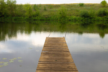 Obraz premium fishing bridge by the river. mooring for boats on the lake