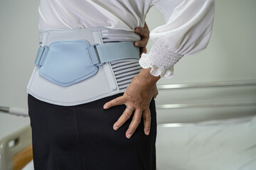 Asian lady patient wearing back pain support belt for orthopedic lumbar with walker.