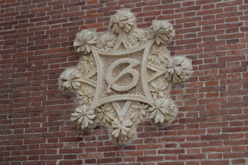 Modernisme stone element with flowers on a brick facade of one of the modernist pavilions of the San Pau i Santa Creu hospital in Barcelona. Spain