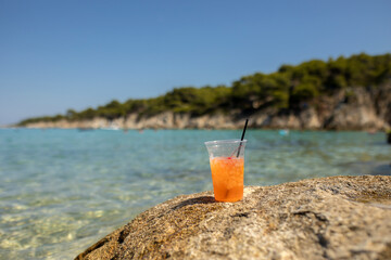 Woman on the beach, drinking coctail in the water, enjoying summer