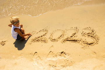 Child, playing on the beach in the sand, enjoying summer, number sign