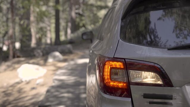Car reverses into a campground parking space and comes to a stop.