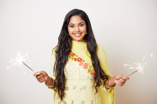 Indian pretty young woman celebrating Diwali festival with fire crackers.  