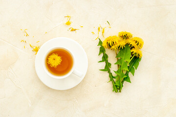 Cup of healing herbal tea with yellow dandelions flowers