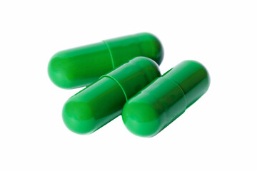 Three green capsules with medicine on isolated white background. Dietary supplement.