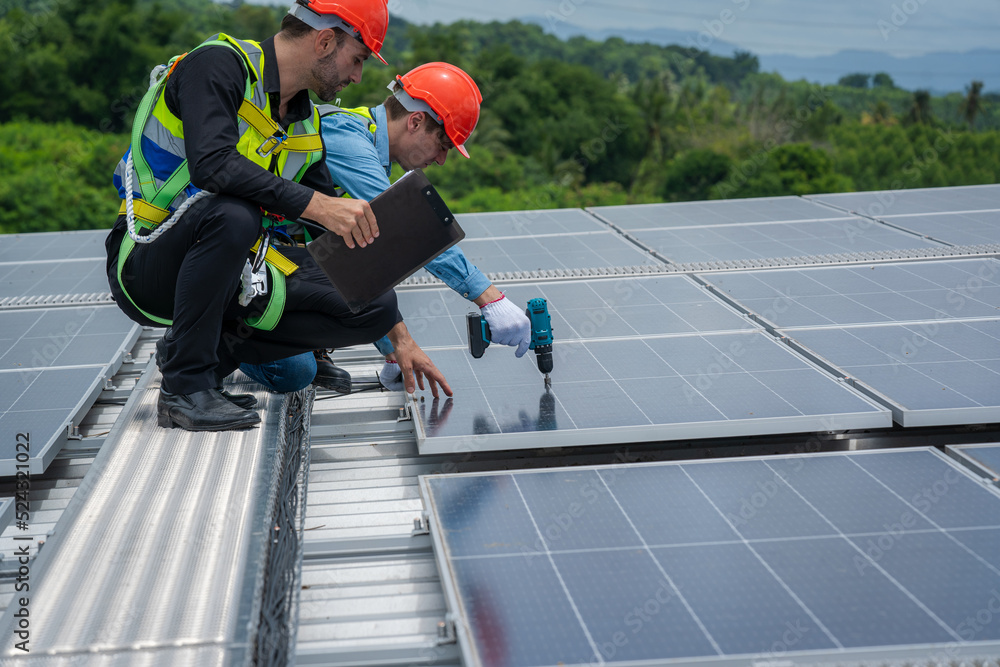 Poster engineers checking the operation of the system solar cell on roof at factory,alternative energy to c