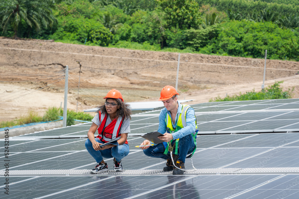 Poster engineers checking solar panel on the roof of factory.