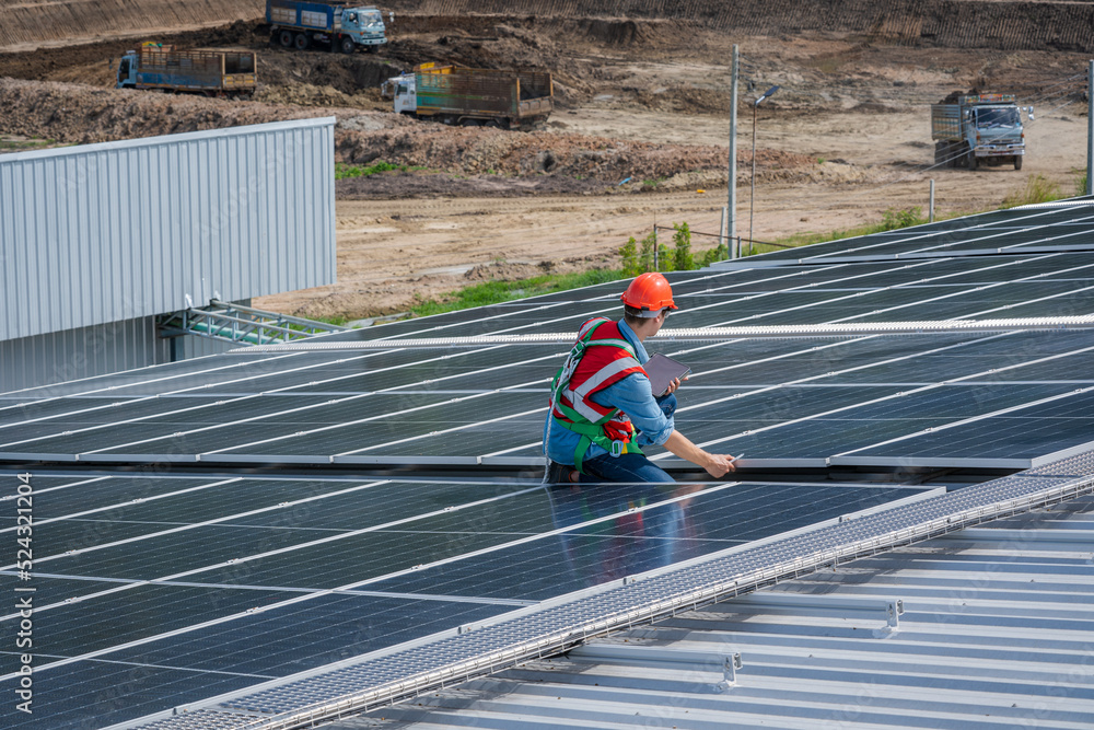 Poster engineer working and checking on solar panels on roof of factory,ecological,using natural renewable 