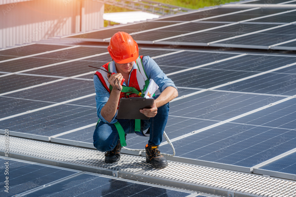 Poster engineers checking the operation of the system solar cell on an building in an residential area,phot