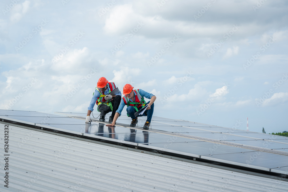 Poster technician wearing safety harness belt during installing the solar panels on roof structure of build