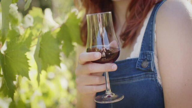 Girl with goblet of red wine near bunch of grapes