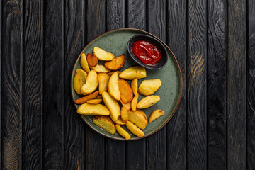 Fried potato wedges served with ketchup tomato sauce