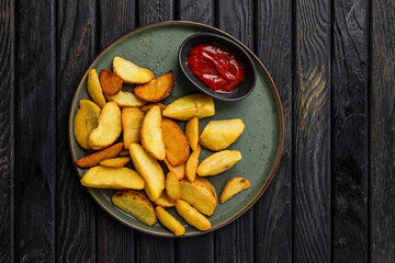 Fried potato wedges served with ketchup tomato sauce