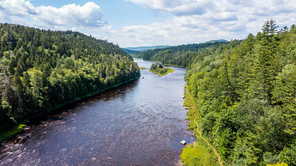 Fototapeta na wymiar Drone View of Green Mountain Landscape, Summer Season in Canada, Water Stream flowing between Forest. 