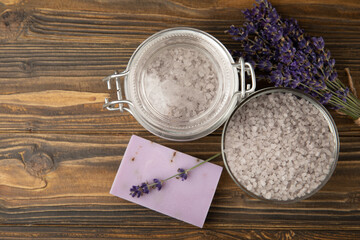 Lavender spa. Sea salt, lavender flowers, essential oils, body cream and handmade soap. Natural herbal cosmetics with lavender flowers on brown texture background. Relax and spa concept.Space for text