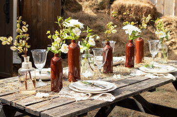 set table at a rural wedding. cutlery, plates and glasses