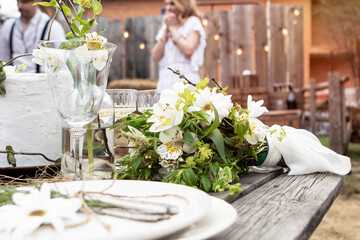 set table at a rural wedding. cutlery, plates and glasses