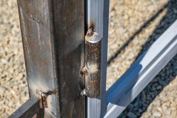 Metal hinge on the gate. A greasy loop when installing a metal structure.