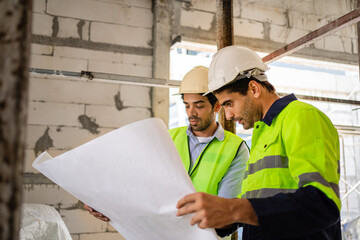 A team of skilled engineers working with construction workers. Concept Architecture and Teamwork Engineers and architects working together on construction projects