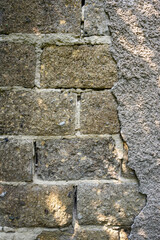 old cinder block wall with destroyed cement plaster