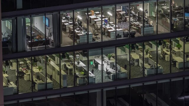 Big glowing windows in modern office buildings timelapse at night, in rows of windows light shines. Open space working places