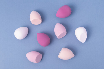 Set of makeup soft sponges on blue background. Top view