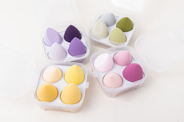 Sets of multi-colored makeup sponges on white background
