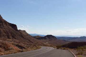 Fototapeta premium Curvy scenic winding desert highway Northshore road follows ancient red mountains more often than edges of the renowned lake