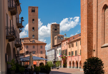View of Duomo square with the town hall among old houses and medieval towers under beautiful sky in Alba, Langhe, Piedmont, Italy. - obrazy, fototapety, plakaty