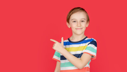 Portrait cute little boy with pointing to empty place on background, surprised preschooler showing copy space for promotional ad. Portrait joyful child pointing at free space for advertisement