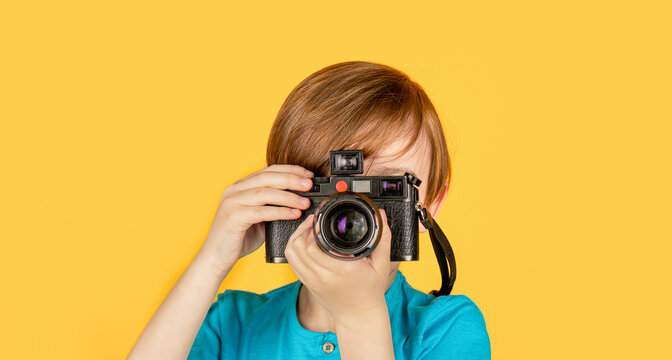 Boy using a cameras. Baby boy with camera. Cheerful smiling child holding a cameras. Little boy on a taking a photo using a vintage camera. Child in studio with professional camera