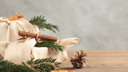 Zero waste christmas concept. Packed in natural fabric gifts and decorations from natural materials on gray table, copy space