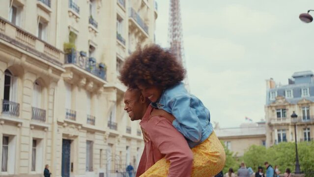 Happy multiethnic beautiful couple in love visiting Paris. Young man and woman on vacation in the french capital city, walking and doing activities around the eiffel tower area	