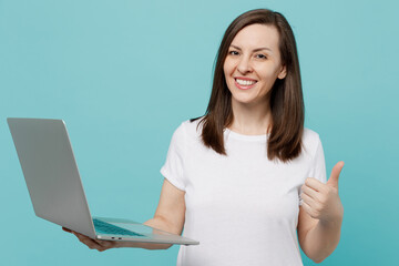 Young smiling happy fun caucasian woman she wearing white t-shirt hold use work on laptop pc...