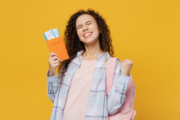 Traveler black teen girl student wear casual clothes hold passport tickets do winner gesture isolated on plain yellow background. Tourist travel high school study abroad getaway. Air flight concept.