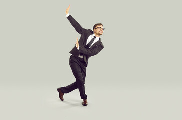 Full body studio portrait of happy graceful businessman or office worker having fun after work day...