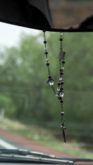 a crucifix hanging from car's mirror