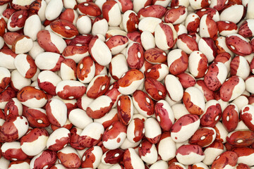 View from above on a pile of raw red with white speckled kidney beans. Closeup