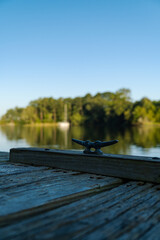 pier with cleat and sailboat in the distance