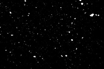 Falling snow freeze motion in the dark sky. Texture isolated on black background. Perfect for white snowflakes overlay, winter mood