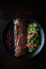 zenith view of ribs with barbacue dish on a table of a fancy restaurant