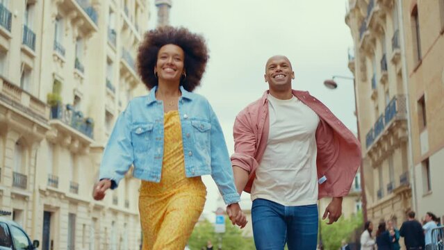 Happy multiethnic beautiful couple in love visiting Paris. Young man and woman on vacation in the french capital city, walking and doing activities around the eiffel tower area	