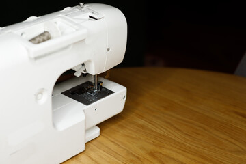 white sewing machine on a wooden table tool