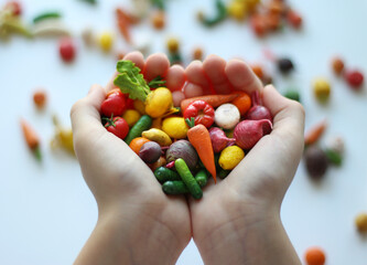 Miniature vegetables in hands. toy products. Montessori. Polymer vegetables and fruits in children's hands.