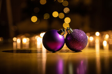 Purple Christmas balls lie on the background of garland lights. New Year's background