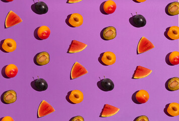 Pattern of differently cut samples watermelon and plums on violet background. Summer minimal concept