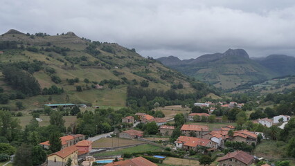 Fototapeta na wymiar Vue panoramique du village de Lierganes, sur le sommet d'une colline, zone campagnard, sous un temps pluvieux, humide et gris, nuagueux