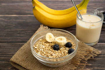 Banana, oatmeal, milk on a wooden background