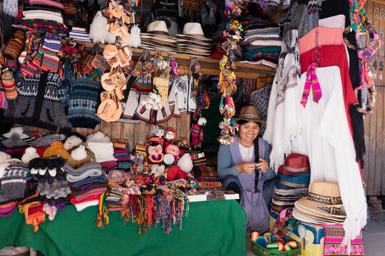 Mujer latina sonriendo y trabajando en una típica tienda de recuerdos