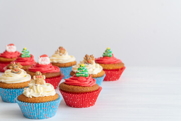 Assortment of Christmas Cupcakes on Table with Copy Space and White Background